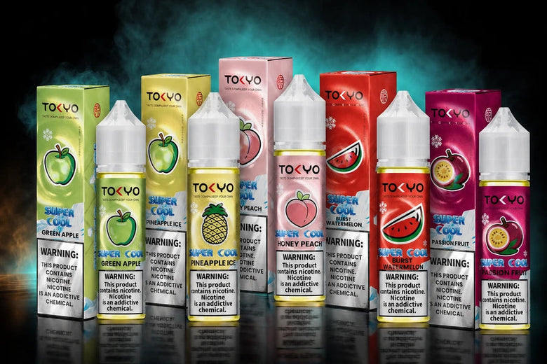 A promotional display of multiple Tokyo Vapes e-liquid bottles and boxes in different fruit flavors, including papaya, mango, pineapple, strawberry, watermelon, and passion fruit, arranged on a dark reflective surface with a black background and large text reading 'Free Base E-Liquid' and 'Free Base Explore'.